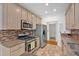 Well-lit kitchen with granite countertops, mosaic backsplash, stainless steel appliances, and neutral-toned cabinetry at 4309 Milford Pl, Hoschton, GA 30548
