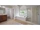 Bathroom featuring a bathtub, glass shower, neutral paint, and tile floors at 5737 Russell Ct, Douglasville, GA 30135