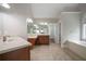 Primary bathroom with double sinks, white countertops, and separate soaking tub at 5737 Russell Ct, Douglasville, GA 30135