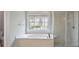 Bright bathroom featuring a soaking tub under a window, and a separate glass shower at 5737 Russell Ct, Douglasville, GA 30135