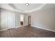 Spacious bedroom with hardwood floors, tray ceiling, and access to a bathroom at 5737 Russell Ct, Douglasville, GA 30135