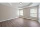 Bedroom showcasing hardwood floors, tray ceiling and bright, sunlit windows at 5737 Russell Ct, Douglasville, GA 30135