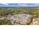 Aerial view of a residential neighborhood surrounded by lush greenery and a distant lake at 6070 Arbor Green Cir, Sugar Hill, GA 30518