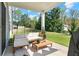 Comfortable covered patio featuring stylish outdoor furniture and a view of the green backyard at 6070 Arbor Green Cir, Sugar Hill, GA 30518