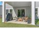 Cozy covered patio area with furniture, a grill, and a tranquil backyard setting at 6070 Arbor Green Cir, Sugar Hill, GA 30518