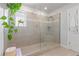 A glass enclosed shower stall is featured in this bathroom with gray tiled walls and floor at 6070 Arbor Green Cir, Sugar Hill, GA 30518