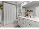Well-lit bathroom with double vanity, white cabinets, and a shower-tub combo, designed for comfort at 6070 Arbor Green Cir, Sugar Hill, GA 30518