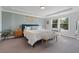 This is a bedroom with a blue accent wall, a blue headboard, carpeted floors and a bench at the end of the bed at 6070 Arbor Green Cir, Sugar Hill, GA 30518