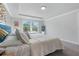 This is a bedroom with gray walls, carpeted floors, a bed with white and gray bedding, and windows that provide natural light at 6070 Arbor Green Cir, Sugar Hill, GA 30518