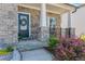 Charming front entrance with a stone facade, a wreath on the door, and decorative landscaping at 6070 Arbor Green Cir, Sugar Hill, GA 30518
