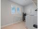 Bright laundry room featuring a modern washer and dryer setup with natural light from the window at 6070 Arbor Green Cir, Sugar Hill, GA 30518