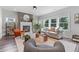 Inviting living room with fireplace, hardwood floors, and large windows for natural light and outdoor views at 6070 Arbor Green Cir, Sugar Hill, GA 30518