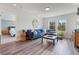Comfortable living room with large blue sofa, wood-style flooring, and a view to the outside at 6070 Arbor Green Cir, Sugar Hill, GA 30518