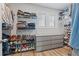 This is a well-organized walk-in closet, with shelving for shoes and folded clothing, and natural light at 6070 Arbor Green Cir, Sugar Hill, GA 30518