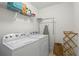 Neat laundry room equipped with washer, dryer, and overhead storage shelving at 1723 Highlands Se Vw, Smyrna, GA 30082