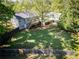 Aerial view of large, grassy, fenced backyard featuring a fire pit and mature trees at 20 Old Oak Ct, Covington, GA 30016