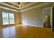 Generous bedroom featuring a tray ceiling, natural light, and wood floors at 20 Old Oak Ct, Covington, GA 30016