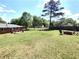 Spacious backyard with mature trees, fire pit, and deck, offering plenty of space for outdoor activities and relaxation at 3556 Forest Hill Rd, Powder Springs, GA 30127