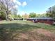 Expansive backyard with a wooden deck, a lush lawn, and mature trees at 3556 Forest Hill Rd, Powder Springs, GA 30127