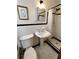 Classic bathroom with a pedestal sink and a shower featuring black and white tile at 3556 Forest Hill Rd, Powder Springs, GA 30127