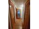 Hallway with wood floors, complemented by two closets and a frosted glass door at the end at 3556 Forest Hill Rd, Powder Springs, GA 30127