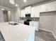 The open kitchen features white cabinets, stainless appliances, and quartz countertops at 1217 Fern Ridge Ct # 16, Norcross, GA 30093