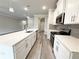 The open kitchen has white cabinets, stainless appliances, and center island with sink at 1217 Fern Ridge Ct # 16, Norcross, GA 30093