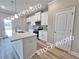 A modern kitchen features an island with white cabinets, quartz countertops, and stainless appliances at 1217 Fern Ridge Ct # 16, Norcross, GA 30093