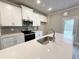 Kitchen features stainless appliances, white cabinets, gray backsplash, and a center island at 1217 Fern Ridge Ct # 16, Norcross, GA 30093