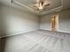 Large bedroom featuring neutral paint, a tray ceiling with fan and carpet flooring at 1227 Fern Ridge Ct # 17, Norcross, GA 30093