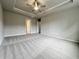 The spacious bedroom has neutral colored walls, carpet and a tray ceiling with a ceiling fan at 1227 Fern Ridge Ct # 17, Norcross, GA 30093
