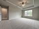Large bedroom featuring a trey ceiling with ceiling fan, neutral paint, carpet, and large window at 1227 Fern Ridge Ct # 17, Norcross, GA 30093