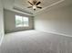 A large bedroom features a ceiling fan, neutral walls, plush carpet and a window at 1237 Fern Ridge Ct # 18, Norcross, GA 30093