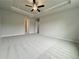 A light-filled bedroom boasts soft carpeting, ceiling fan, and access to an en suite at 1237 Fern Ridge Ct # 18, Norcross, GA 30093