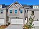 Charming townhome features a two-car garage, brick accents, and a well-maintained front yard, under a clear blue sky at 1237 Fern Ridge Ct # 18, Norcross, GA 30093