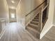 Inviting foyer with gray wood-look flooring, paneled walls, and a staircase with carpeted steps and decorative iron railings at 1237 Fern Ridge Ct # 18, Norcross, GA 30093