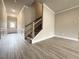 Inviting foyer with a staircase, gray wood-look flooring, paneled walls, and natural light from the front door at 1237 Fern Ridge Ct # 18, Norcross, GA 30093