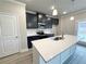 Modern kitchen featuring navy blue cabinets, white quartz countertops, a stainless steel oven, and an island with sink at 1237 Fern Ridge Ct # 18, Norcross, GA 30093