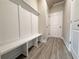 Mudroom with built-in bench and storage, light gray wood-look floors, and access to the garage at 1237 Fern Ridge Ct # 18, Norcross, GA 30093
