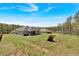 Large backyard with a gentle slope, bordered by mature trees, offers ample space for outdoor activities at 173 Bramlett Ridge Dr, Dallas, GA 30157