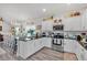 Open kitchen with white cabinets, stainless appliances, black countertops, adjacent dining area, and hardwood floors at 173 Bramlett Ridge Dr, Dallas, GA 30157