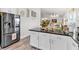 Kitchen island with white cabinets, black countertops, stainless steel refrigerator, and adjacent dining area at 173 Bramlett Ridge Dr, Dallas, GA 30157