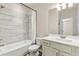 Bright bathroom featuring modern fixtures, a shower-tub combo with tiled wall, and a vanity with a large mirror at 1602 Dover Creek Ln, Lawrenceville, GA 30045