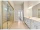 Luxury bathroom with dual sinks, modern cabinetry, and a spacious frameless glass shower enclosure with tile surround at 1602 Dover Creek Ln, Lawrenceville, GA 30045