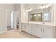 Contemporary bathroom with dual sinks, sleek cabinets, large mirror, and a frameless glass shower enclosure at 1602 Dover Creek Ln, Lawrenceville, GA 30045