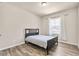 Neutral bedroom with wood-look flooring, a bed, and a window offering natural light at 1602 Dover Creek Ln, Lawrenceville, GA 30045