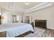 This bedroom boasts a decorative trey ceiling, wood-look floors, and a neutral color palette at 1602 Dover Creek Ln, Lawrenceville, GA 30045