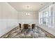 Bright dining room with stylish rug, wainscoting, modern chandelier, and large window for natural light at 1602 Dover Creek Ln, Lawrenceville, GA 30045