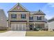 Charming two-story home with a stone and siding exterior, a well-manicured lawn, and a two-car garage at 1602 Dover Creek Ln, Lawrenceville, GA 30045