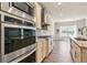 Kitchen boasts stainless steel appliances, granite countertops and tile backsplash with an adjacent living area at 1602 Dover Creek Ln, Lawrenceville, GA 30045